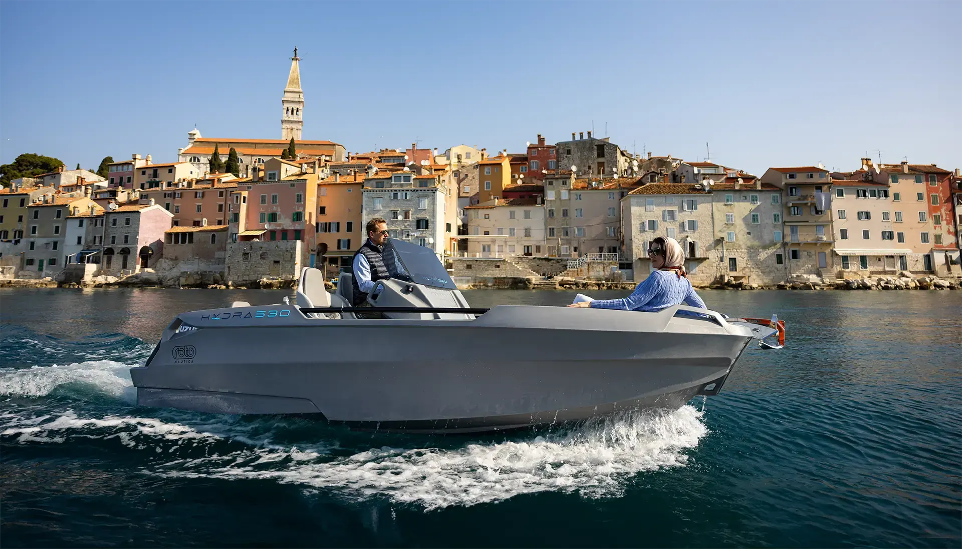 Hydra 530 navegando frente a un casco antiguo mediterráneo